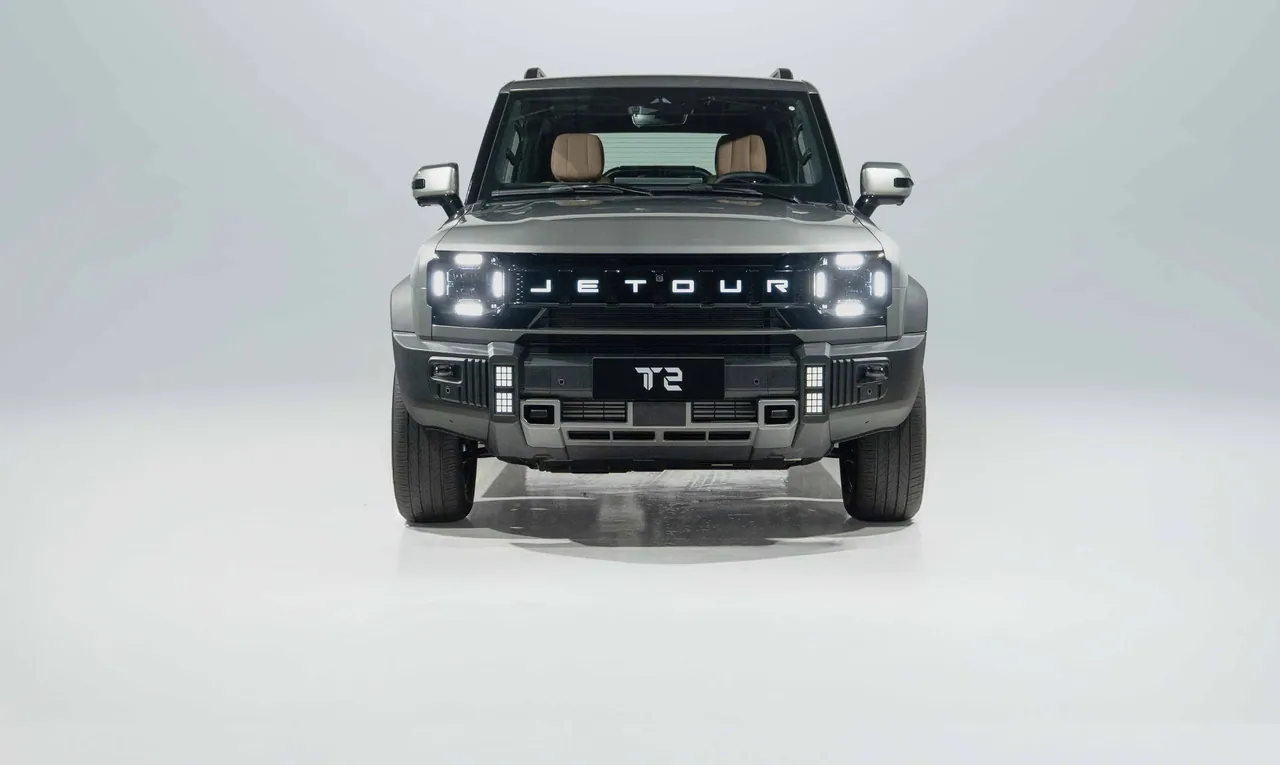 Jetour T2 from the front on the studio floor, lamps lit